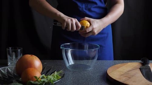 Person Zests Lemon over Clear Bowl