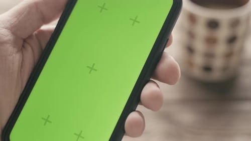 Man Shows a Green Screen of a Cell Phone Closeup