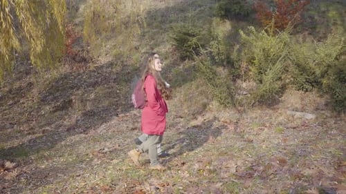 Positive Young Biracial Couple with Backpacks Walking in the Autumn Forest. Hippie Man and Woman in