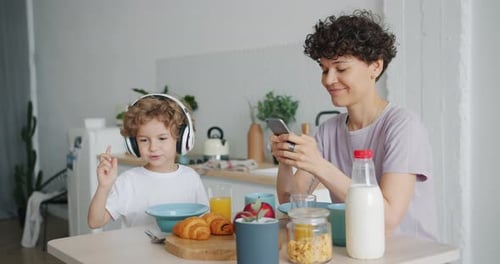 Mother and Child Listening to Music at Breakfast
