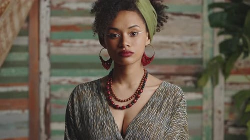 Woman Poses with Head Wrap, Stylish Dress and Jewelry