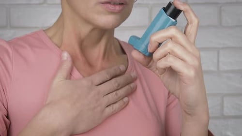 Adult Using Asthma Inhaler Close Up