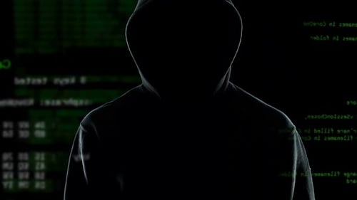 Hooded Silhouette in Front of Coding Background