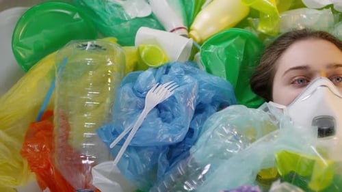 Woman Lying in Plastic Waste Wearing Mask