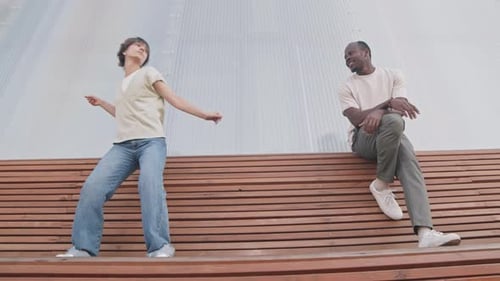 Woman Dancing for Friend on Urban Wooden Platform