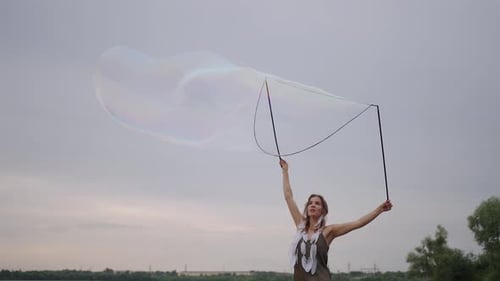Woman Creates Huge Soap Bubbles with Wand Outdoors