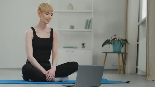 Woman Doing Yoga with Laptop at Home