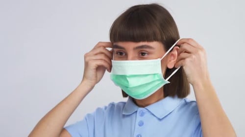 Woman Puts On Protective Surgical Mask