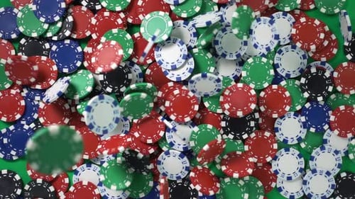 Colorful Casino Chips Falling onto Green Surface