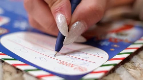 Hand Writes Note on Christmas Card