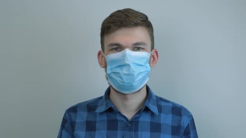 Young Adult Wearing Surgical Mask Looking at Camera