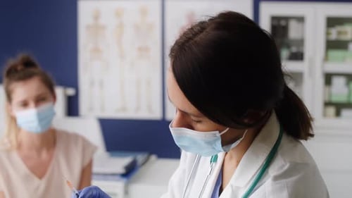 Doctor Prepares Vaccine Injection for Patient in Clinic