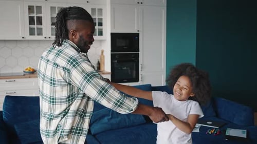 Happy Positive African American Father Dancing with His Little Daughter at Home Laughing and Having
