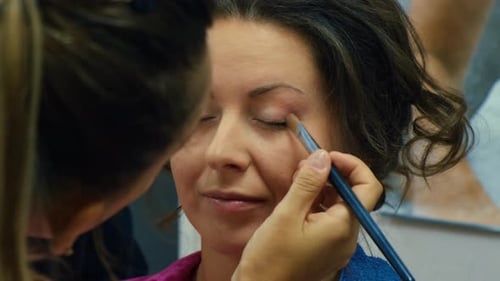 Makeup Artist Applying Eyeshadow to a Woman