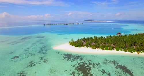Aerial drone view of a scenic tropical island resort hotel in the Maldives