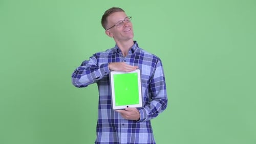 Man Holds Tablet with Green Screen for Compositing