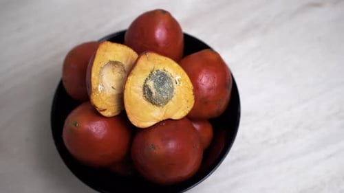 4K de haut en bas montrant de nombreux fruits de Chontaduro dans un bol sur la table, gros plan - prores
