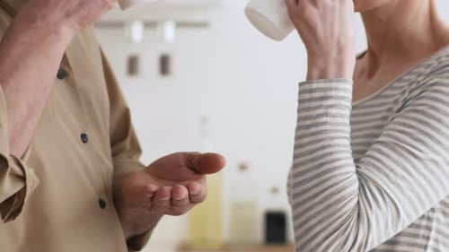 Couple Chatting and Drinking in Kitchen, Close Up