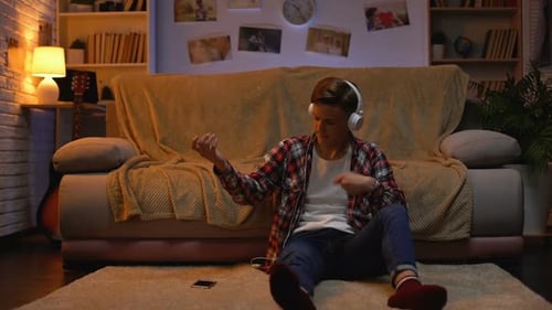 Teen Enjoying Music with Headphones in Cozy Home