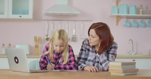 Mother and Child Study Together in Bright Kitchen