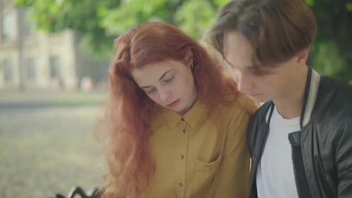 Young Woman and Man Talk in the City Park