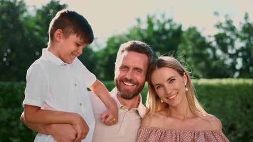 Happy Family Smiling Together in Green Park Setting