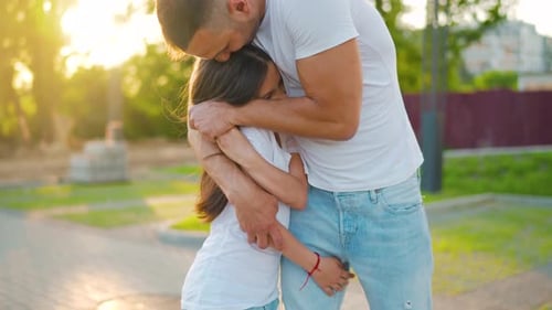 Loving Father and Daughter Embrace in Sunny Park