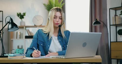 Woman Works from Home with Headset and Laptop