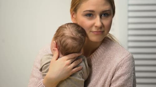Young Female Holding Healthy Newborn Baby in Arms, Loving and Tender Mommy