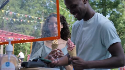 Young Couple Buying Ice Cream Cones Together