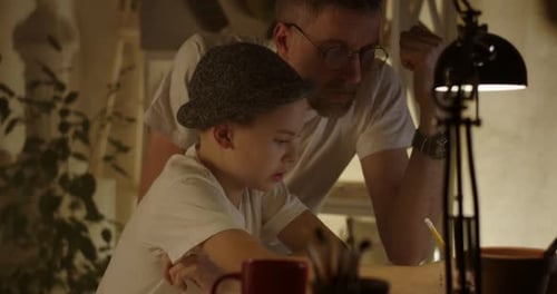 Father Helping Son Learning To Draw