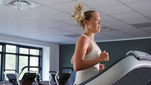 Woman Jogging on Treadmill in Gym