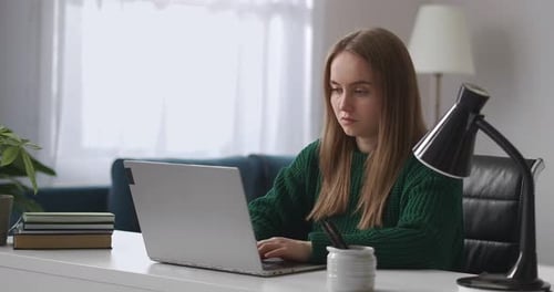 Freelancer Woman Is Working with Notebook in Home Office Sitting at Table and Typing on Keyboard