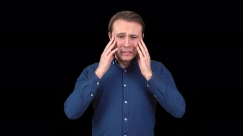 Man with Light Brown Hair Crying Against Black Background