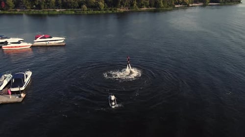 Un jeune homme fait du flyboard près de la jetée. Entraînement. Coucher de soleil. Vue par Drone.