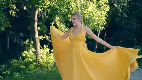 Woman in Yellow Dress Dancing in a Park