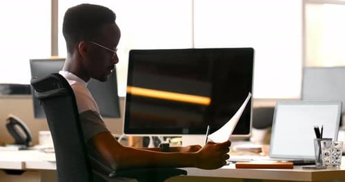 Male Executive Checking Document at Desk 4k