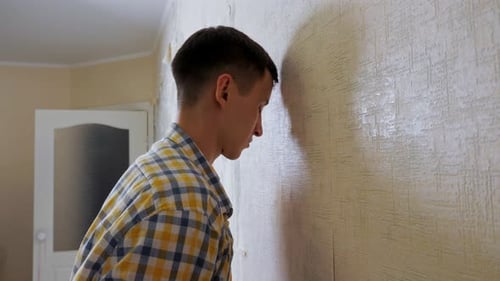 Depressed Guy in Checkered Shirt Hits Room Wall with Head