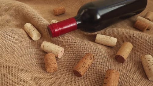 Wine in bottle and falling corks on the bag. Slow motion.