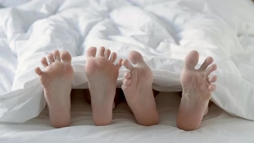 Passionate Loving Couple Having Sex Under White Blanket in Bedroom Close Up of Male and Female Feet