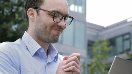 Man Works on Laptop in Urban Environment