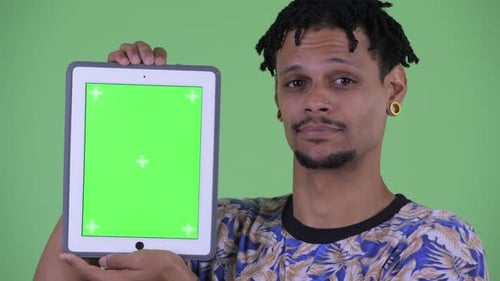Young Adult Holding Tablet with Green Screen Display