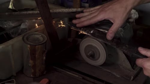 Hand of Man Sharpens Blade of a Knife