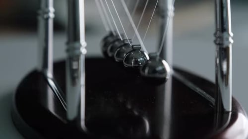 Newton's Cradle Metal Balls Swinging with Kinetic Energy