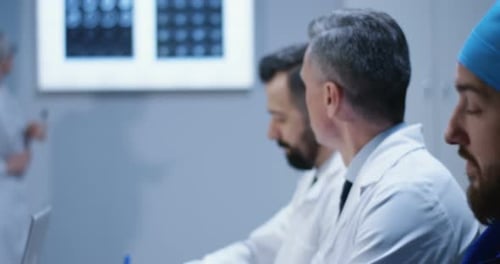 Medical Team Discussing X-Ray Results in Meeting