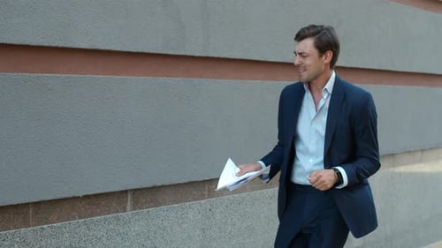 Side View Businessman Celebrating Victory. Man Dancing in Suit Near Building