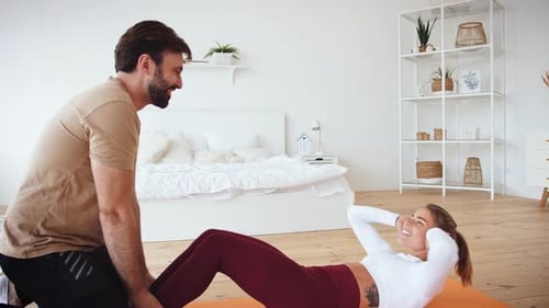 Woman Doing Sit-Ups with Partner Holding Feet