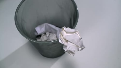 Crumpled Paper Thrown into Metal Trash Can