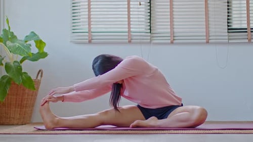 Woman Stretching on Yoga Mat in Bright Home