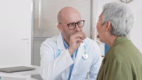 Doctor Examines Patient in Bright Office with Tongue Depressor